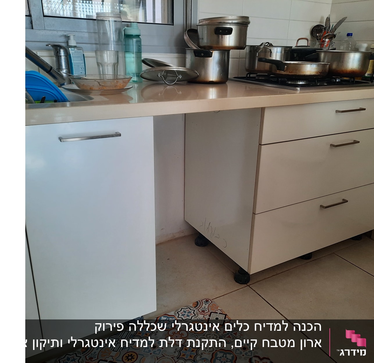 מטבח עם כיור, סירים על הכיריים ובקבוק שמן זית